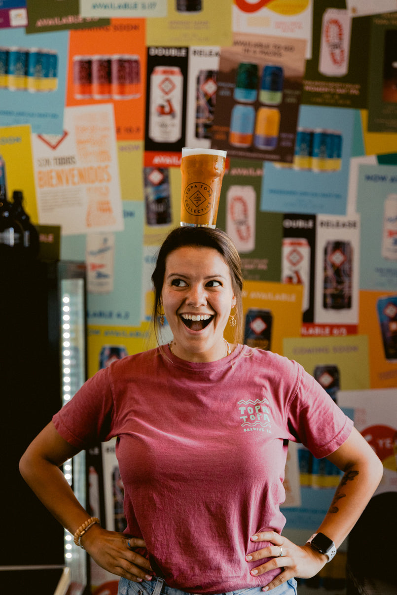 Woman with full glass of beer on top of her head