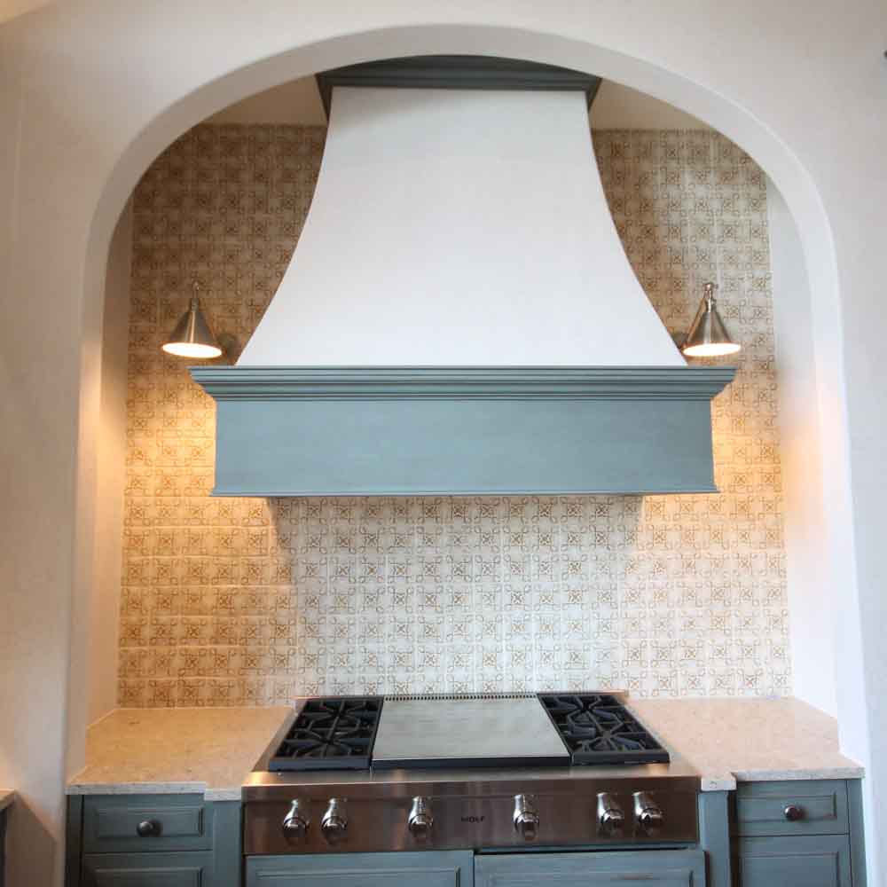 Tuscan range hood with spanish-style kitchen tiles