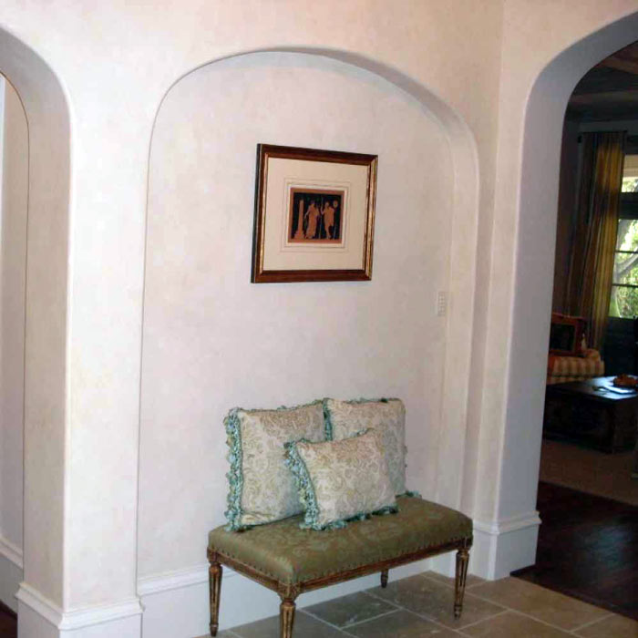 A large wall niche with a soft arch serves as a functional and decorative element for Federal-style home design