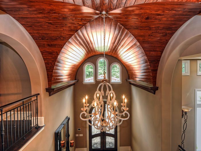 Massive wood-finished groin vault with arched windows in grand foyer 