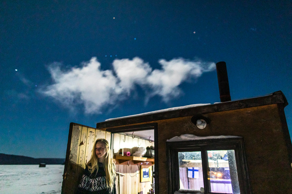 woman looking out from an ice hut under satrry sky - photo david Jackson