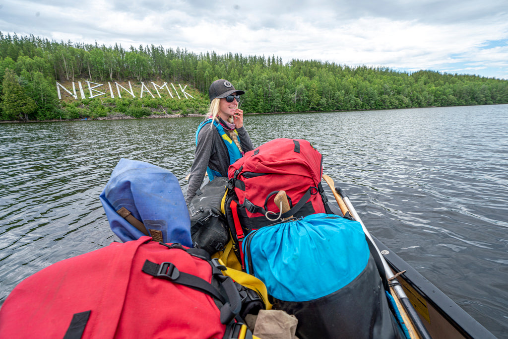 Leah in the canoe in front of the Nibinamik sign