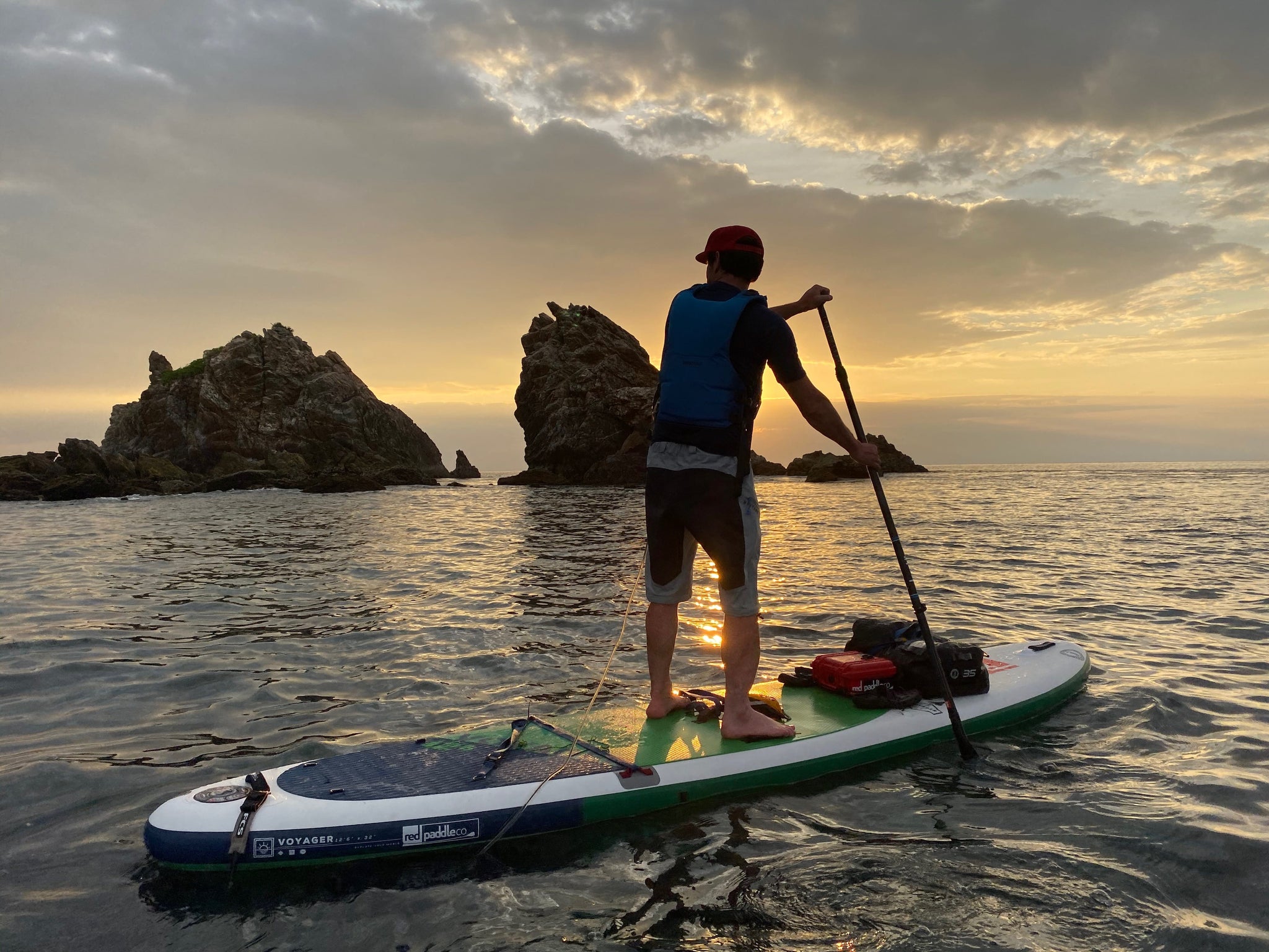 man paddle boarding at sunset