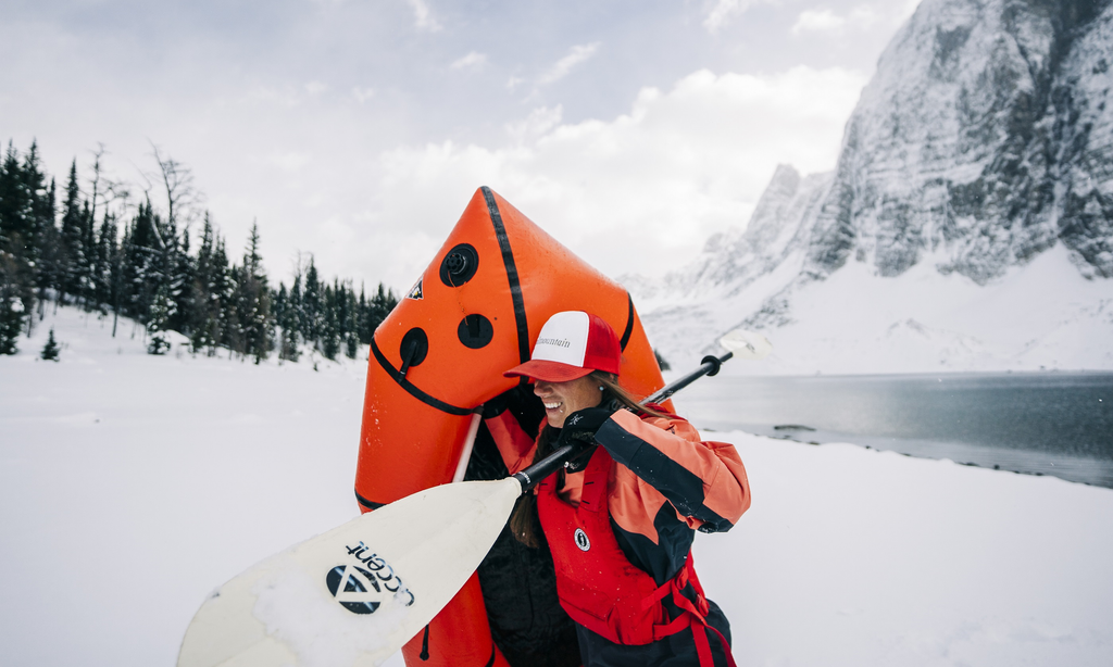 Natalie Panek carrying her pack raft to the winter lake 
