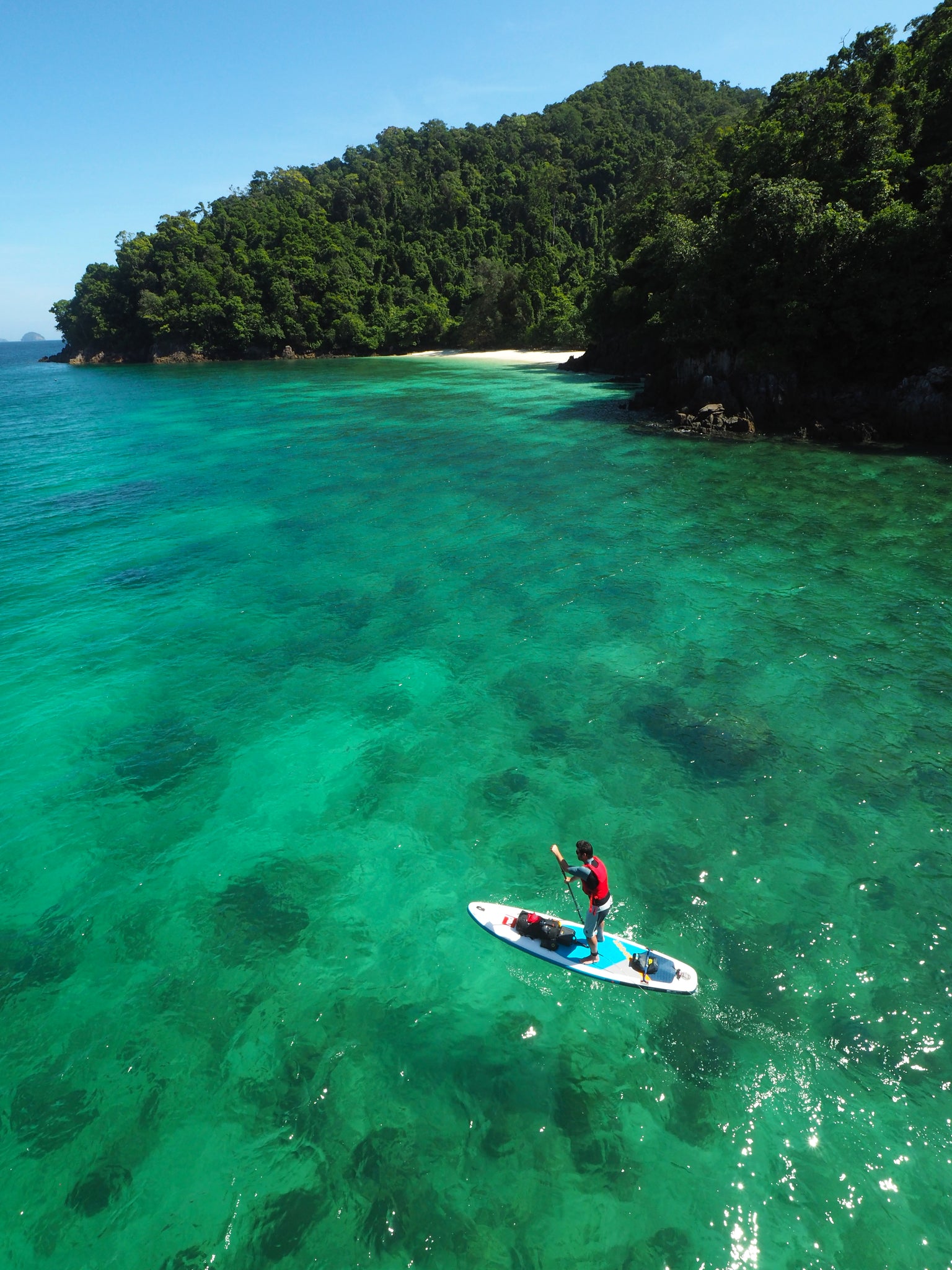 overhead view of paddleboarder in turquoise waters