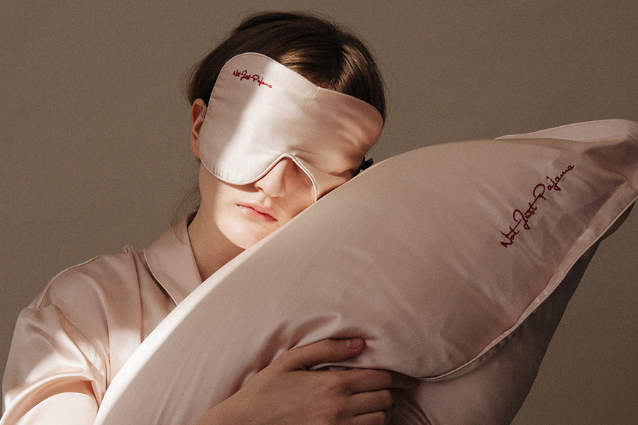woman with white eye mask holding a pillow