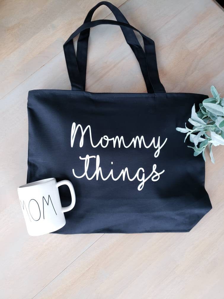 A black tote bag that says “Mommy things