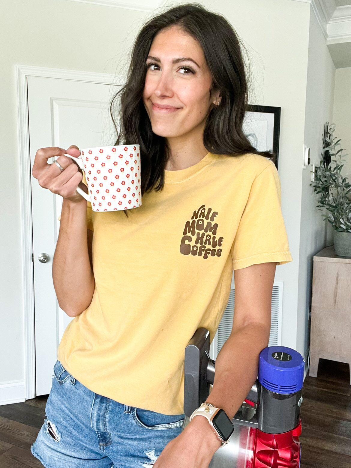 A mom wearing a yellow tee that says Half coffee half mom