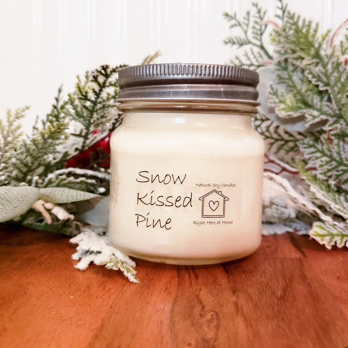 A scented candle named ‘Snow Kissed Pine’ on a table
