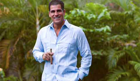 adult man smoking a cigar using a light blue authentic guayabera Ramon Puig