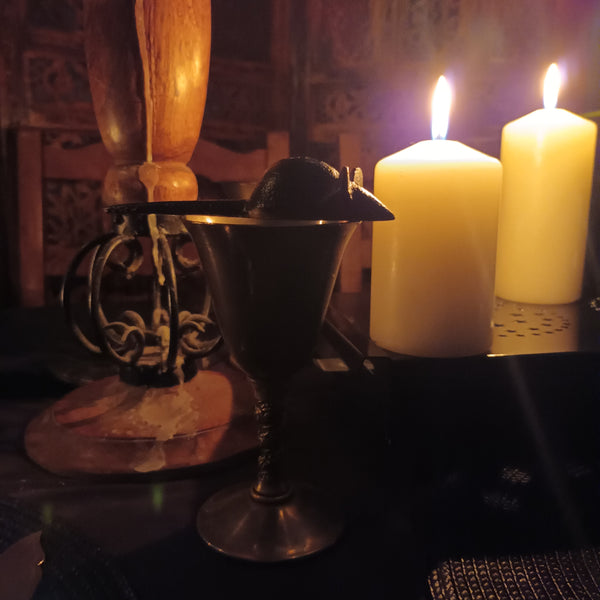 A spooky halloween dinner party table setting in Black with White Candles