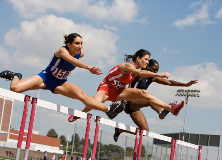 Female athletes hurdling