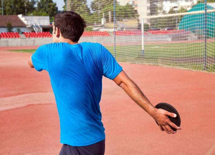 Athlete Throwing Discus on Athletics Track