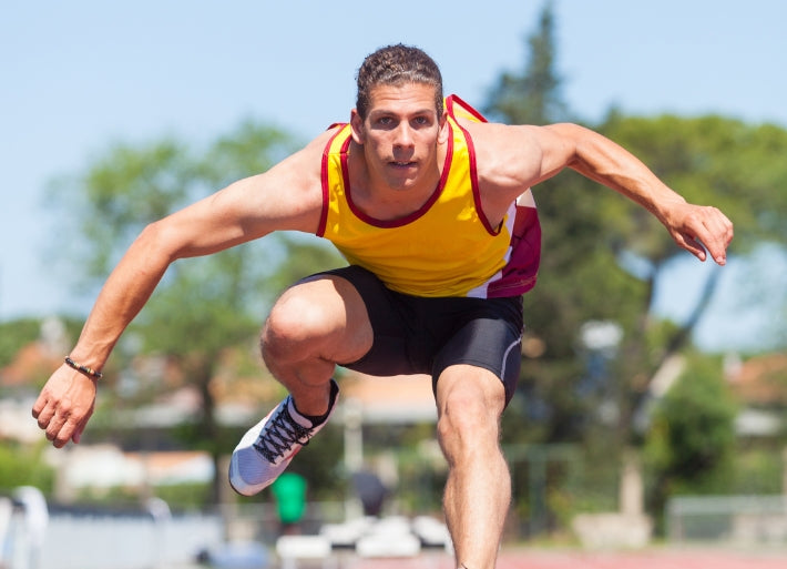Male Decathlete Jumping Over Hurdles
