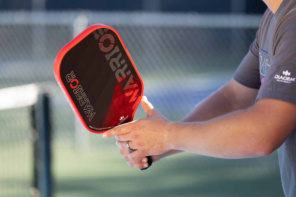 man holds diadem sports warrior pickleball paddle