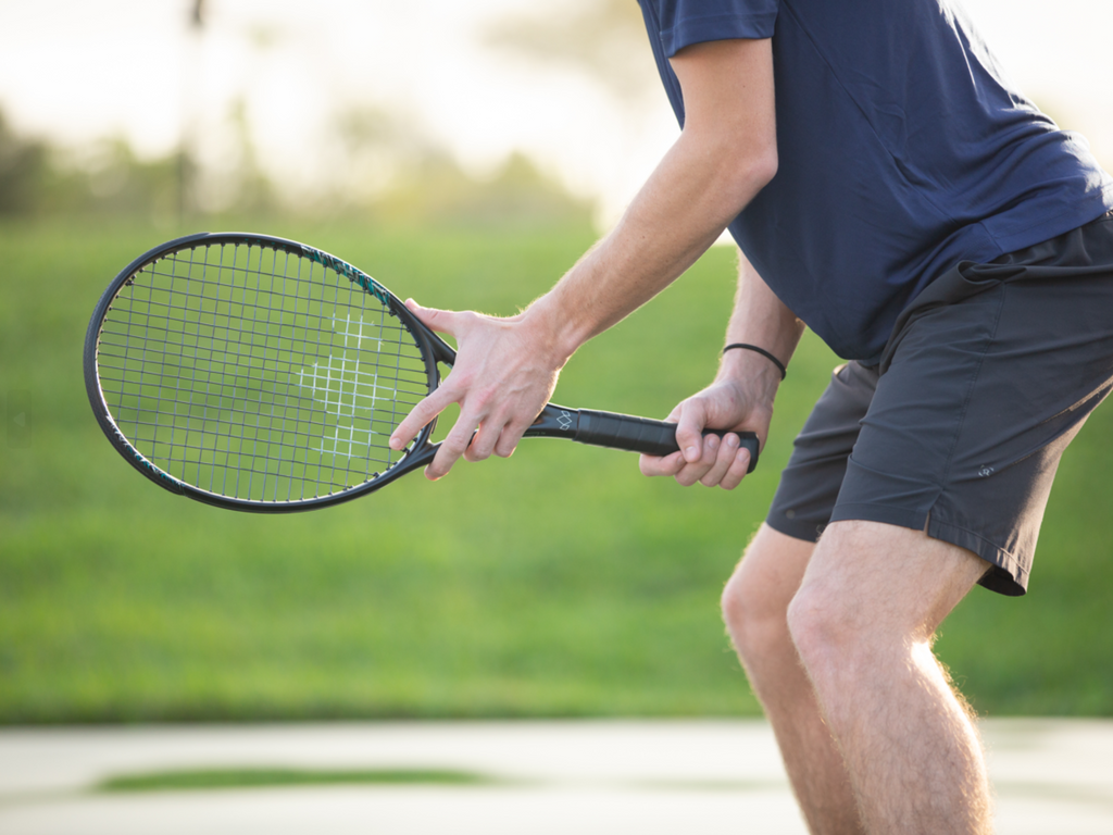 player stands with nova tennis racket