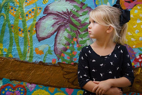 Little girl by painted wall