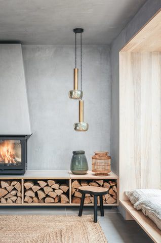 Photograph of Ukiyo interior, focusing on grey clay walls, a cosy fire with wood stacked underneath and minimalisitc scandi furnishings. Thoughtful design comes together to create a refined and relaxing atmosphere. 