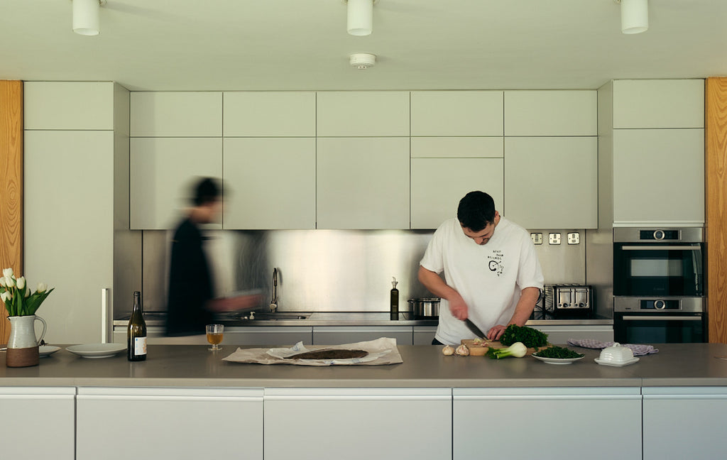 Poeple cooking in modern and minimalistic kitchen. Living Architecture.