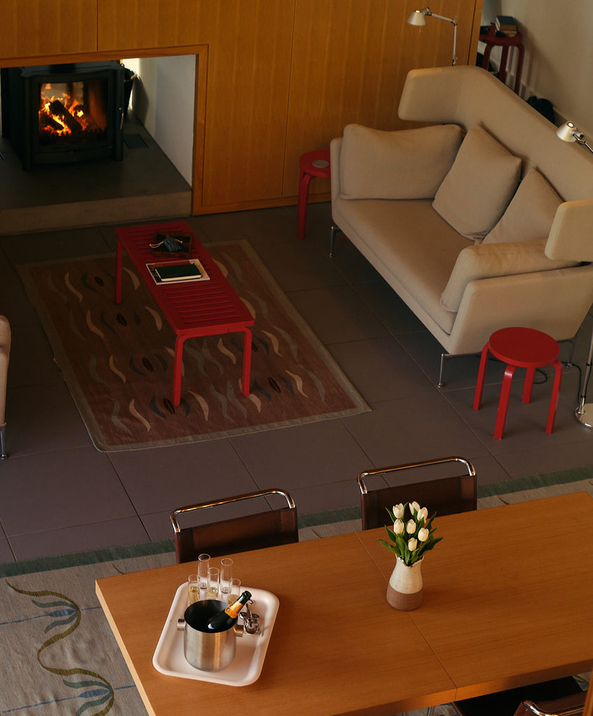 Birds eye view of living space, sofas, lounge area, fire and dining table. Living Architecture.