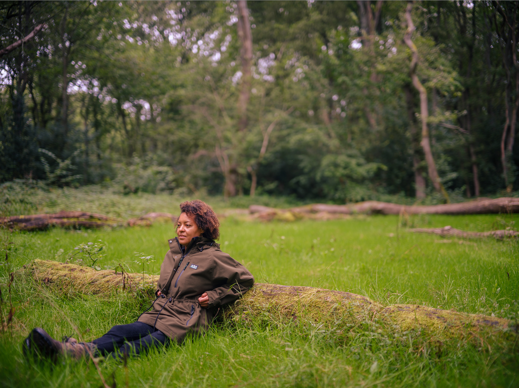 Photo of Beth Collier sat down next to a fallen tree (by Danny North)