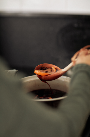 Ladel of mulled wine, from steaming saucepan.