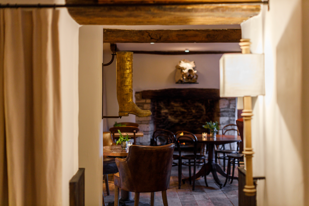 Interior pub showing dark wood tables and roaring fire