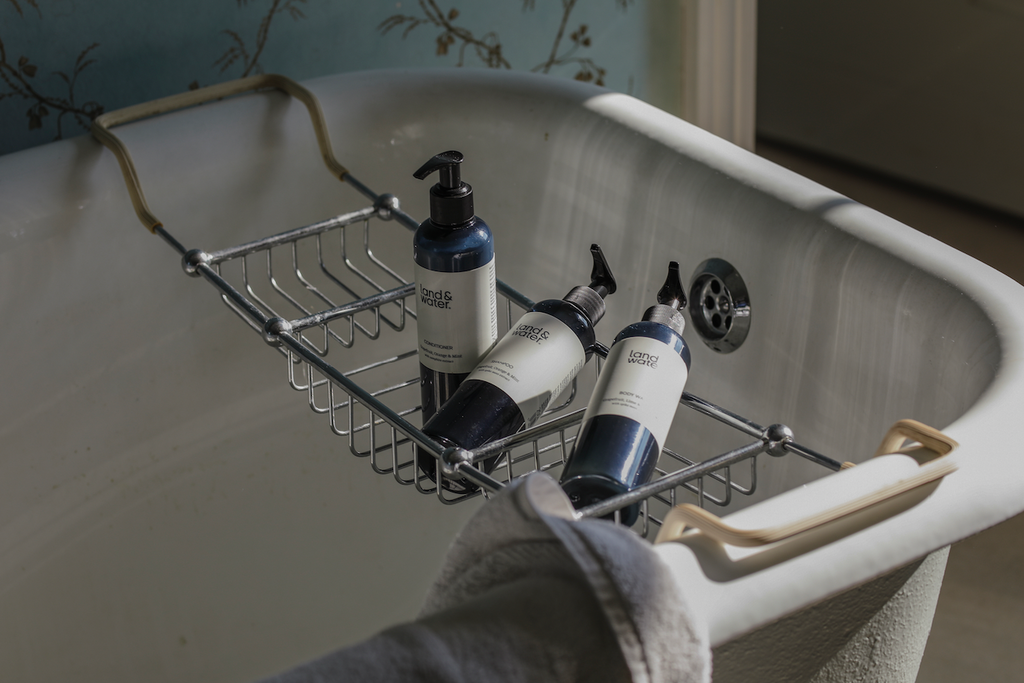 land&water showertime bundle pictured on metal bath rack in roll-top bath.