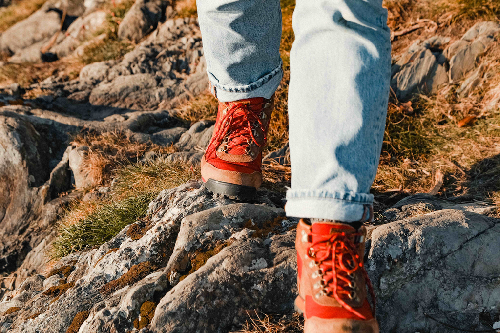 Close-up of walker and red boots, making their way across rugged coast.