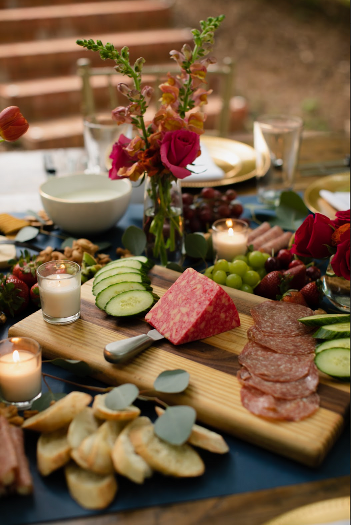 Decorative food display with vase of flowers on table at garden party