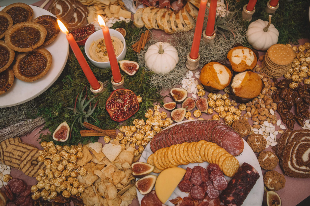fall-themed spread of various foods on table with orange candles