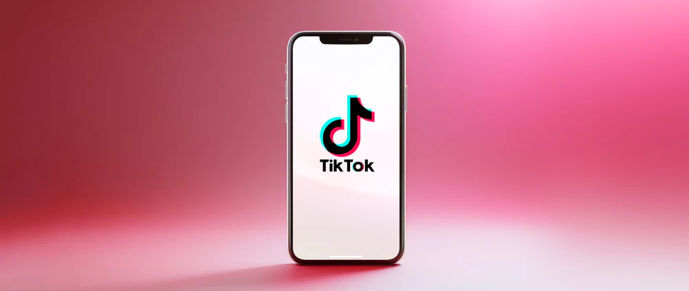  afbeelding van een telefoon met het logo van TikTok op een roze achtergrond
