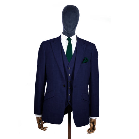 Grüne Strickkrawatte und Einstecktuch mit marineblauem Anzug auf einer Schaufensterpuppe – Mitte