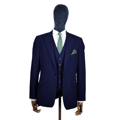 Salbeigrüne Strickkrawatte und Einstecktuch mit marineblauem Anzug auf einer Schaufensterpuppe – Mitte