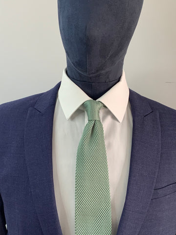Cravate en tricot vert sauge et costume bleu marine