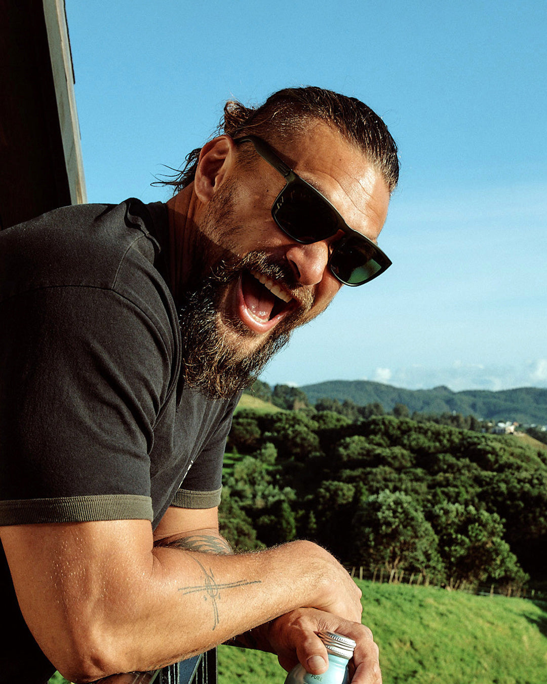 So iLL x On The Roam x Electric sunglasses by jason momoa shown being worn by jason momoa while looking over a ledge