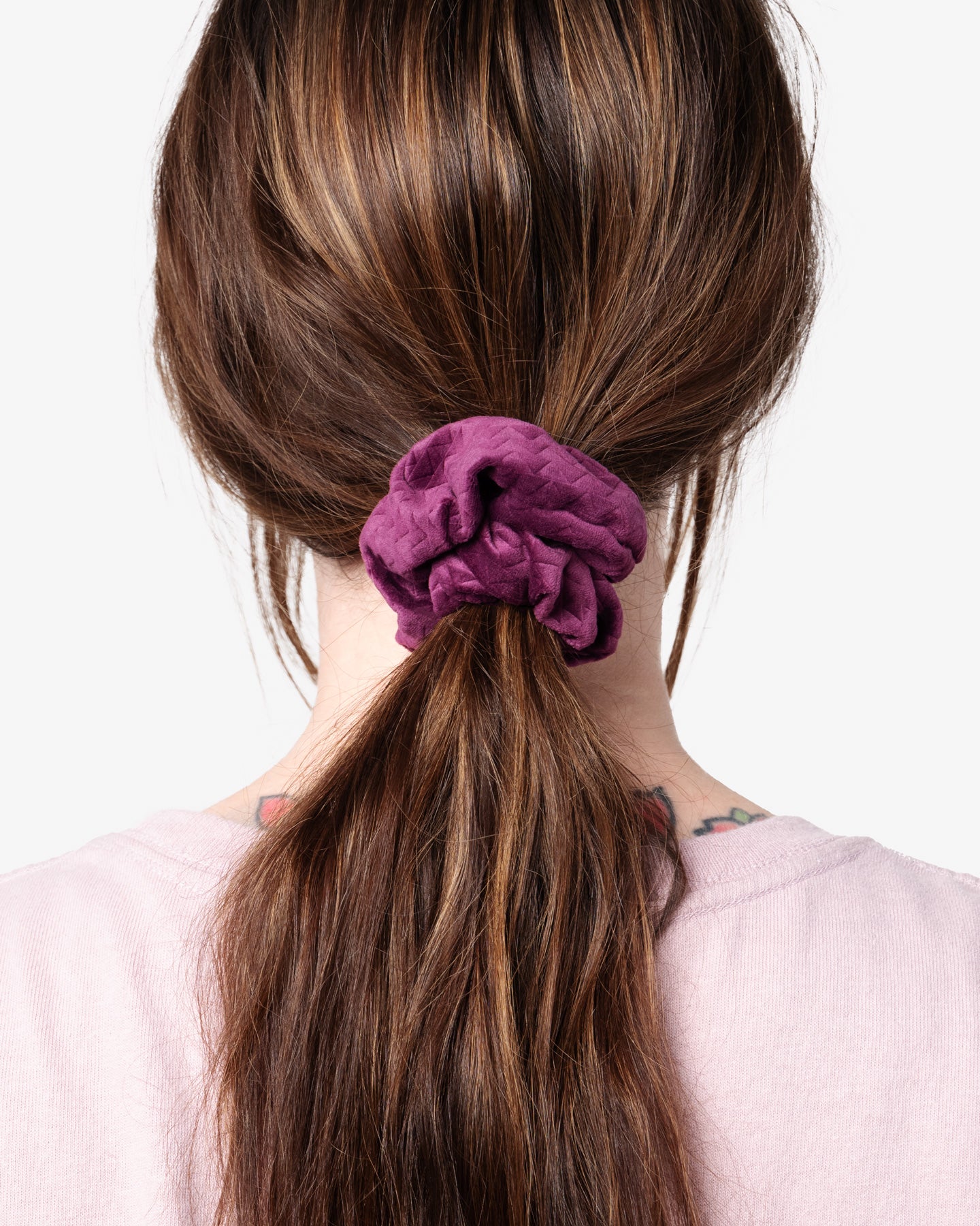 so ill x on the roam scrunchie in unity purple being worn by a woman in her ponytail