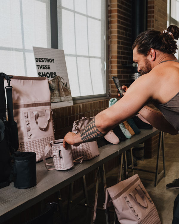 actor and climber jason momoa takes a closer look at samples of his on the roam and so ill collaboration products