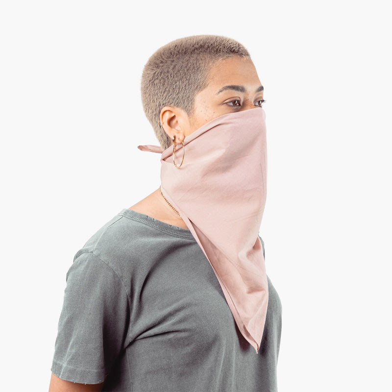 a woman uses the so ill x on the roam bandana as a mask