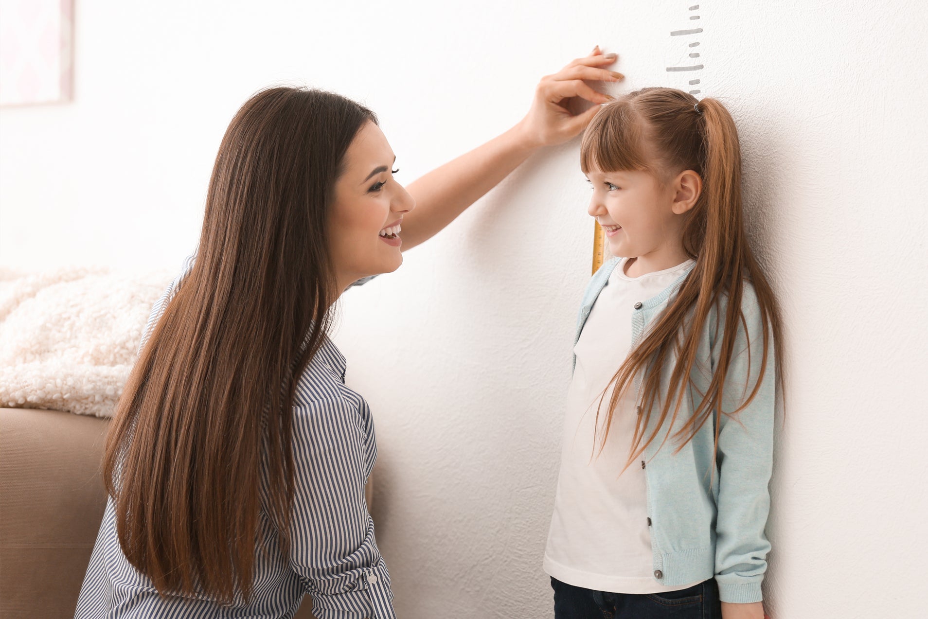 Young Girl Measuring How Much She Has Grown