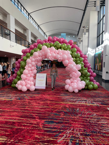 Ashley under the balloon arch at Girl Tribe Pop-Up. 