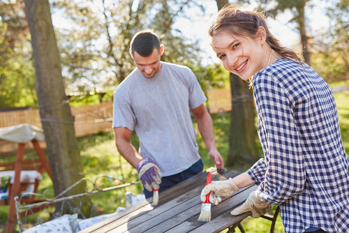 femme-construction-cabane-abris-bois-vernis-jardin