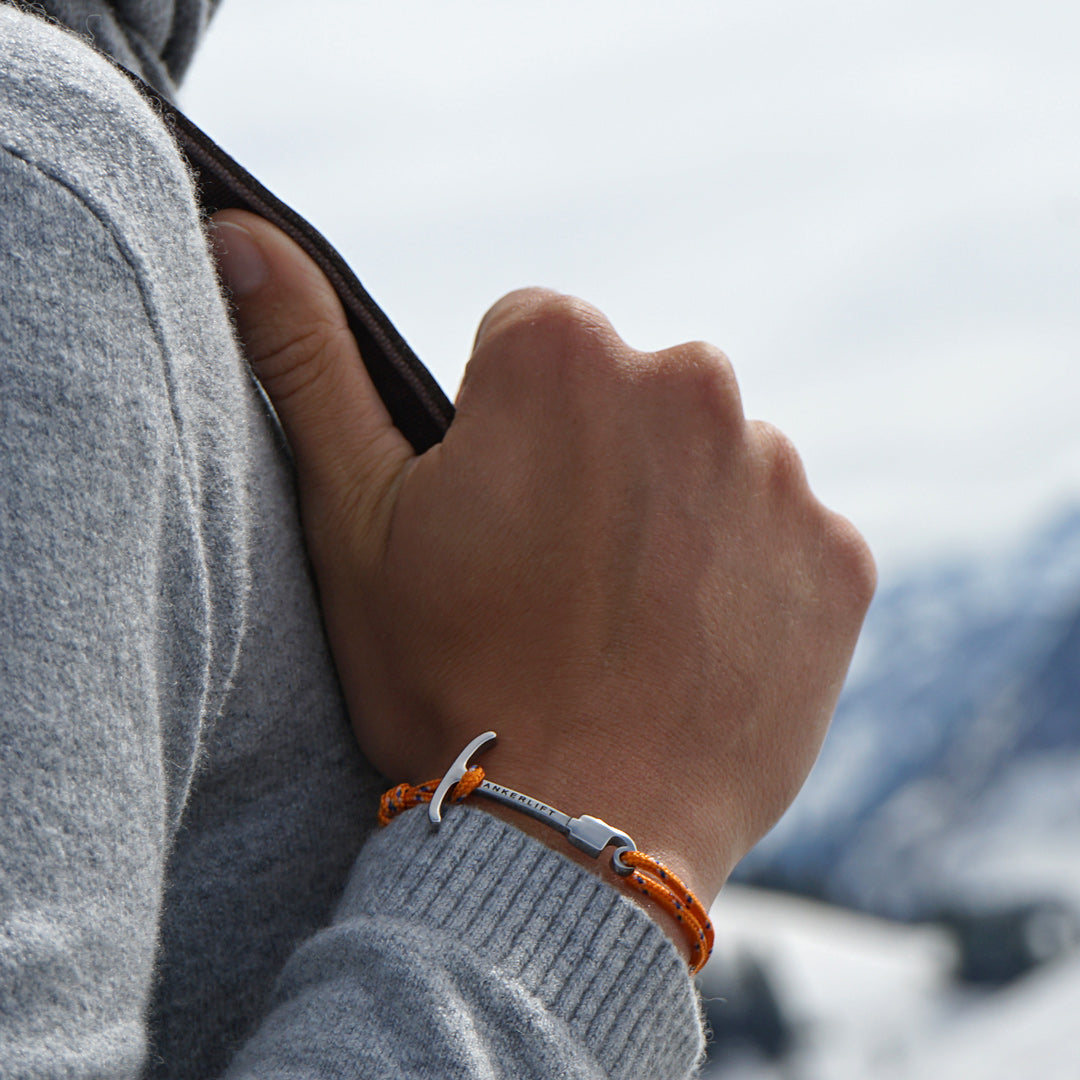 ANKERLIFT Armband orange Handgelenk vor Winterlandschaft 