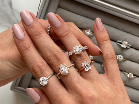 hand wearing engagement rings with natural diamonds