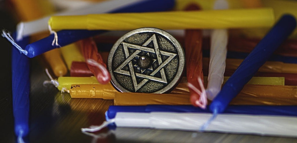 Coin with a Star of David engraved amid Jewish ceremonial candles