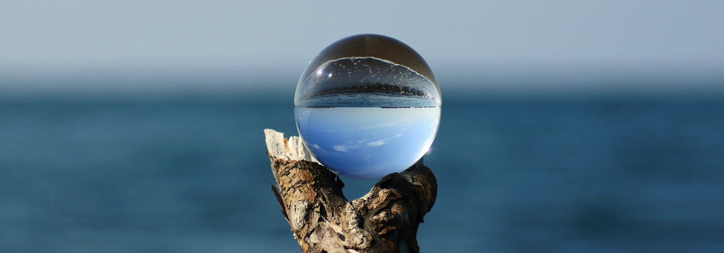 Paysage inversé dans un boule de verre représentant les deux sans dans lequel on peut accrocher le fer à cheval porte-bonheur