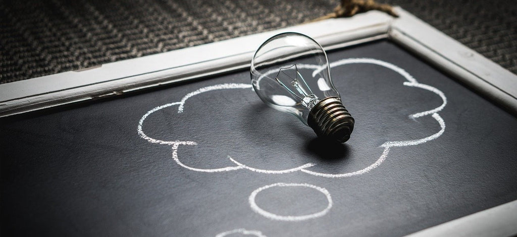 Light bulb symbolizing ideas in a cloud drawn with chalk on a blackboard