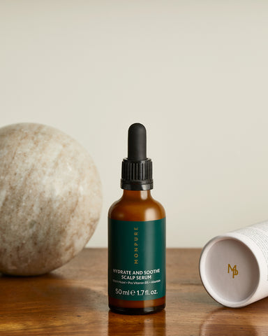 Bottle of MONPURE's Hydrate and Soothe Scalp Serum on a wooden table