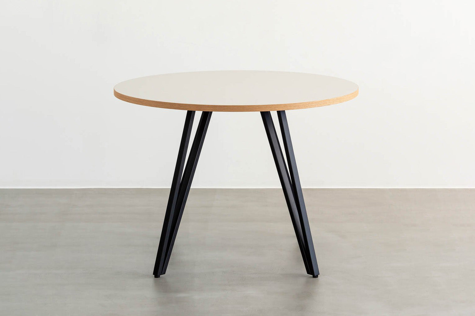 Kanademonoリノリウム・Neroのラウンド天板とデザイン性の高いXラインの脚を組み合わせたカフェテーブル