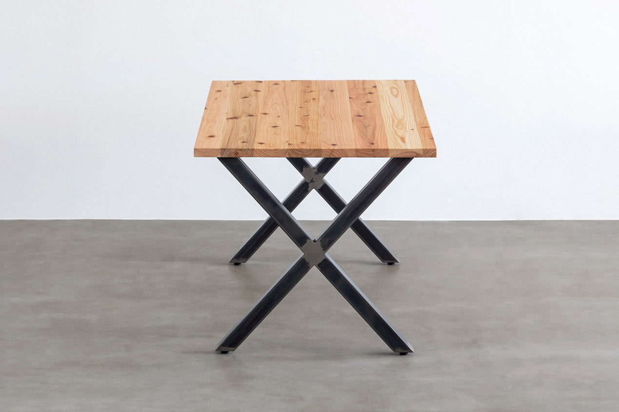 Kanademonoの杉無垢の天板とマットクリア塗装仕上げのX脚を組み合わせたテーブル（横からのアングル）